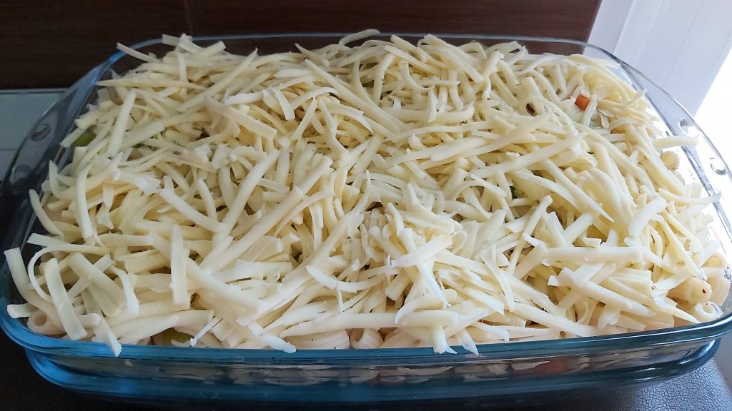 Megkenjük tejföllel, majd megszórjuk sajttal.